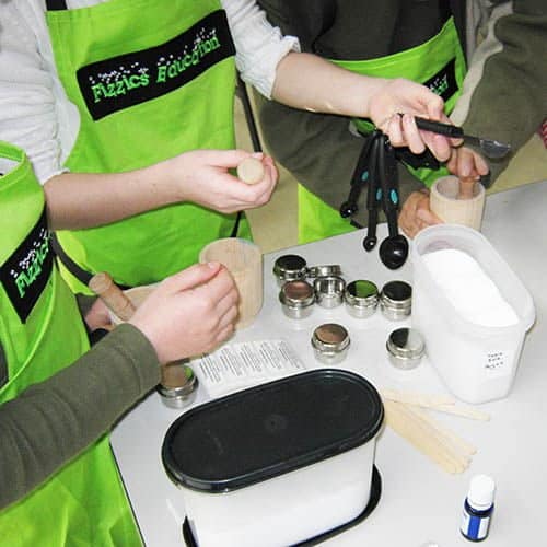 Kids wearing green aprons at a science party