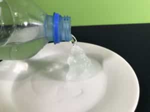 Supercool water science experiment - pouring supercooled water on ice cube