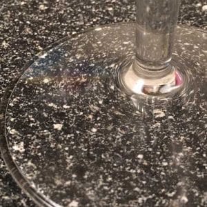 dots on a kitchen counter top being bent by a wine glass