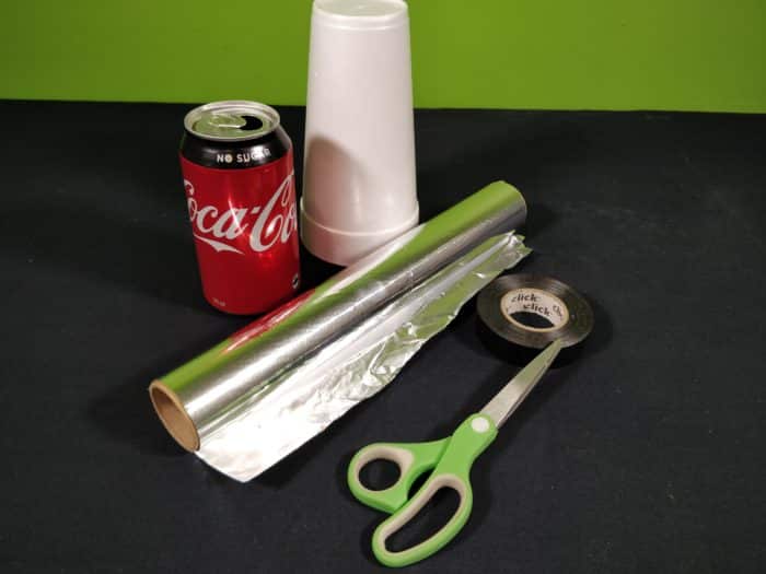 Materials needed for a soda can electroscope showing a soda can, scissors, tape, aluminium foil and a styrofoam cup
