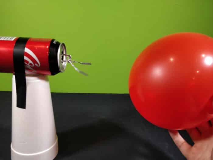 Bringing a charged balloon toward a soda can electroscope - the foil hanging from the ring pull on the can is attracted towards the balloon