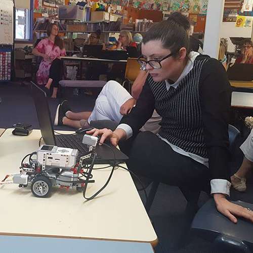 A teacher programming a Lego Mindstorms Robot