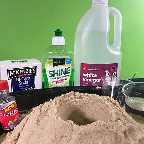 Materials needed for a volcano experiment, Red food colouring, Bi-Carb Soda, Detergent, White vinegar, Sand, Plastic cups, Mixing tool