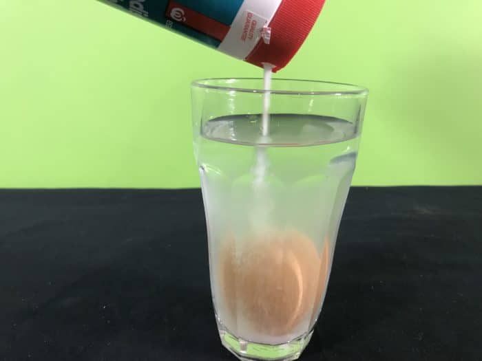 Model the dead sea science experiment - pouring salt into water glass with egg