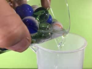 Mysterious Marbles math experiment - pouring the water into the measuring cylinder
