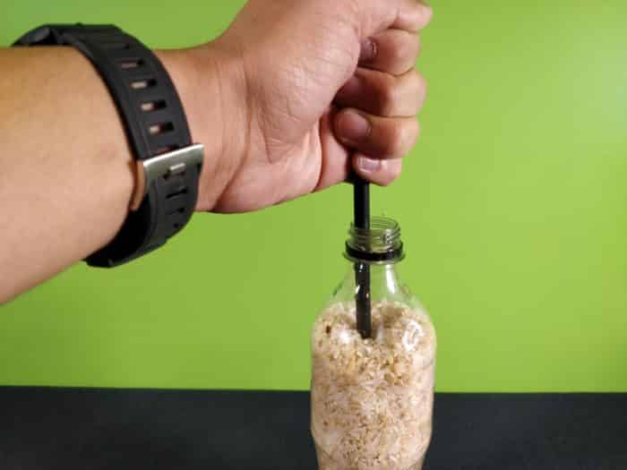 Suspended rice experiment - pushing a pen into a bottle of rice
