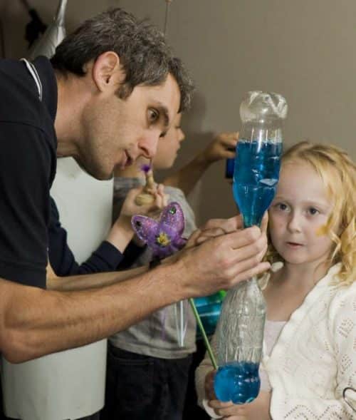 Tornado in a bottle science experiment - showing a young girl a blue tornado in a bottle