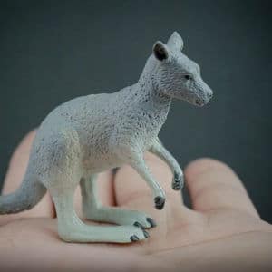 Eastern grey kangaroo replica placed in the palm of a hand. Side view