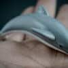 Bottlenose dolphin replica laying on a hand. Side view