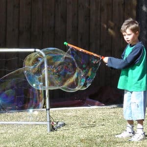 Boy making a big bubble in kids science party