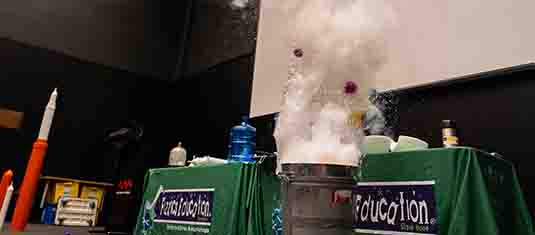 Water erupting from a bin in front of a science presentation desk