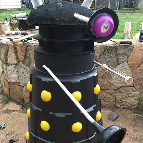 A black dalek decoration made out of a garbage bin, foam and plungers