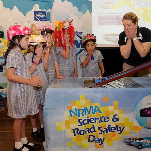 lady with a black shirt showing kids NRMA science & road saftey models