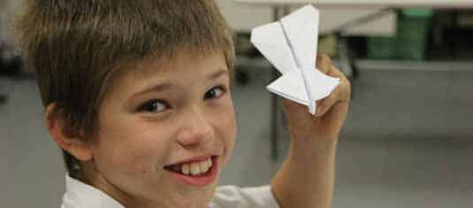 A boy holding a paper plane