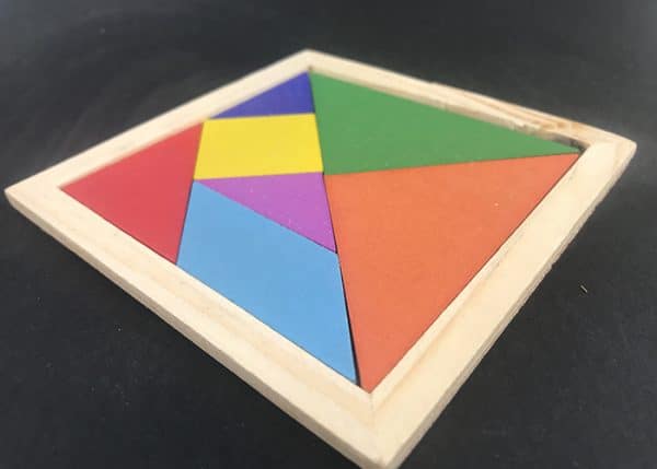 close photo of a Wooden tangram puzzle set in a square