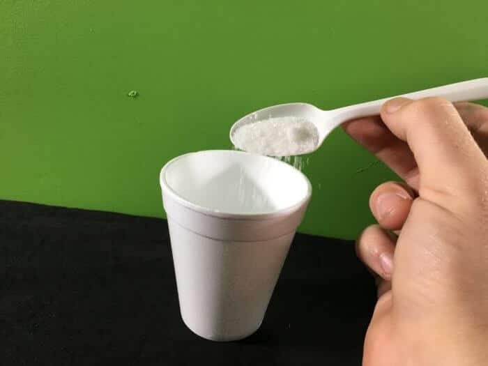 PVA Glue and Borax slime science experiment variant - adding borax powder to a cup