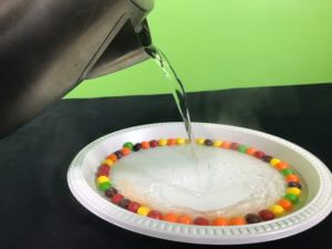 Skittle science experiment hot water version - adding hot water to the plate of skittles