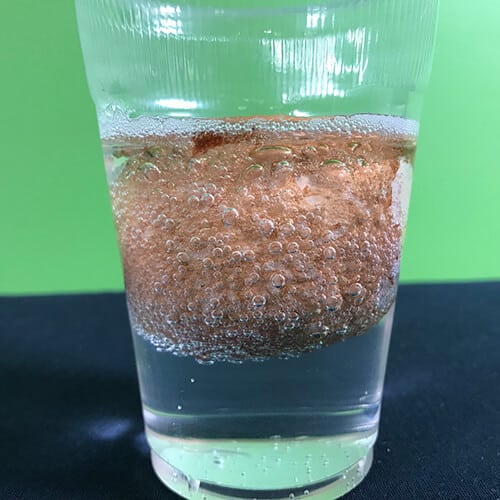 Egg dissolving in a cup half full of water