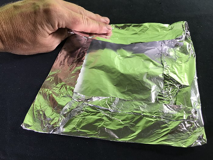 Folding the piece of foil into a square shape