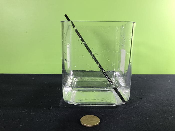 Materials shown for experiment, Straw, Jar of water, Coin
