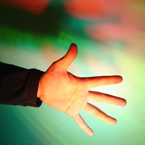 A hand creating red and green shadows on a white screen
