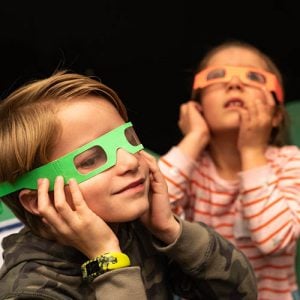 Kids wearing rainbow diffraction glasses