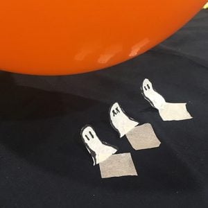 Paper ghosts rising towards a balloon