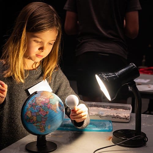 Child with an Earth and moon model