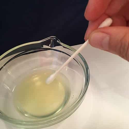Using a cotton tip with the lemon juice