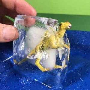 Yellow dinosaur toy stuck in ice