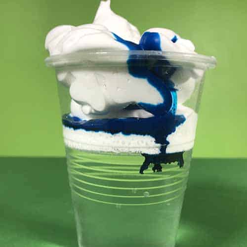 Blue food colouring moving from the shaving cream into the water