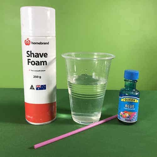 Shaving cream, a plastic cup filled with water, a pink straw and some blue food colouring