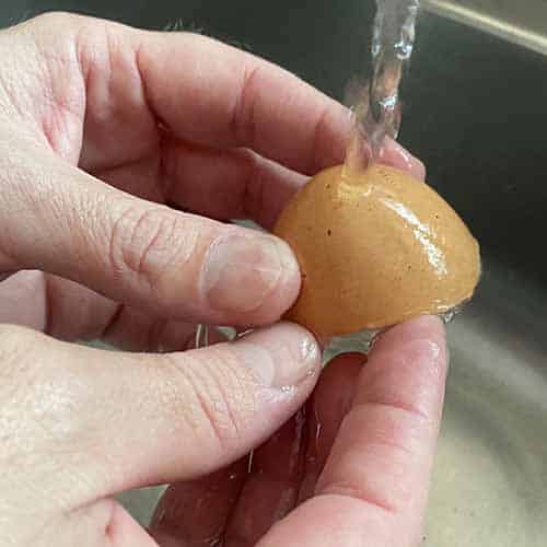 Washing an eggshell under running water