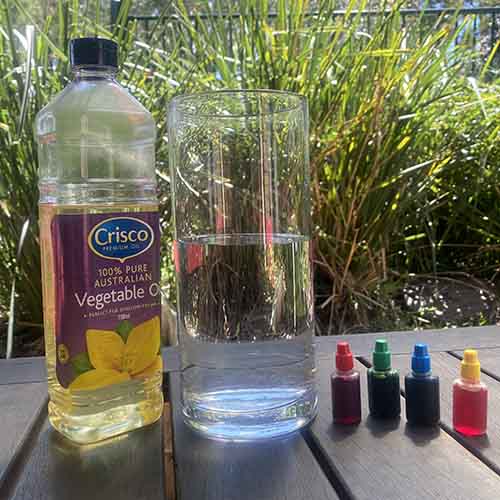 Vegetable oil, 4 food colouring squeeze bottles and a vase filled 2/3 with water