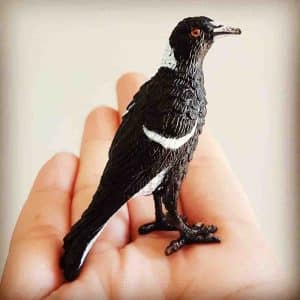 A plastic magpie replica in a hand