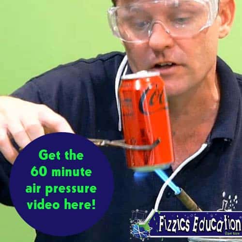 A man holding a soda can with tongs and a bunsen burner heating the can base