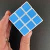 A magic cube held in the hand showing the 9 blue squares of one side