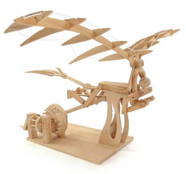 da vinci ornithopter, showing a wooden perons below a pair of wooden wings. The feet are psuhing on a lever that is attached to gears