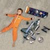 A boy in an astronaut suit next to the floor puzzle, poster and extra pieces