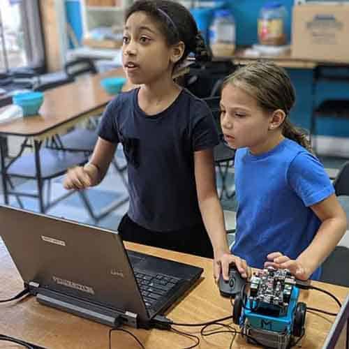 Two girls coding a robot at Dazzling Discoveries center