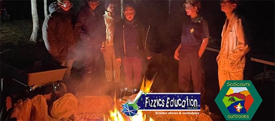 Children standing around a campfire. Logos of Fizzics Education and SciScouts shown
