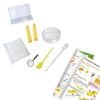 The contents of a roots and shoots science kit. Showing a plastic tray, pipette, spoon, magnifier, yellow sponge, petri dish, booklet